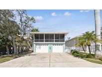 Charming home with a screened-in porch, two-car garage, and driveway at 616 2Nd St, Indian Rocks Beach, FL 33785