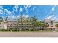 Full exterior view of the condominium complex with multiple balconies, a street view and a landscaped median at 640 Bayway Blvd # 302, Clearwater Beach, FL 33767