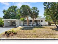 Charming single-story home with mature palm trees, a covered porch, and a well-maintained front yard at 7201 5Th N Ave, St Petersburg, FL 33710