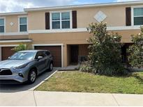 Tan townhouse showing the front door, garage, and landscaping at 7221 Sterling Point Ct, Gibsonton, FL 33534