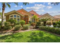 Charming home featuring mature landscaping, a clay tile roof, and a welcoming entrance at 10229 Waterside Oaks Dr, Tampa, FL 33647
