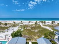 Sweeping beach view, complete with white sand and swaying palms against a blue sky at 1070 Eldorado Ave, Clearwater Beach, FL 33767