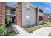 Two-story condo featuring brick accents, gray siding, and a cozy outdoor balcony space, all under a clear blue sky at 1400 Gandy N Blvd # 1504, St Petersburg, FL 33702