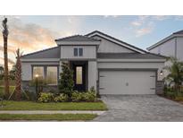 Charming single-Gathering home featuring a well-manicured lawn, stone accents, and a two-car garage at 3818 Farm Garden Ct, Lakewood Ranch, FL 34211