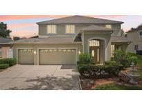 Charming two-story home featuring a three car garage, well-maintained landscaping, and a classic entryway with a decorative door at 4224 Fleewell Ct, Valrico, FL 33596