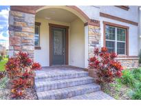 Charming home entrance featuring a stone-accented facade and a decorative front door at 5933 Caldera Ridge Dr, Lithia, FL 33547