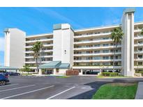 Well-maintained condo building showcasing assigned parking, attractive landscaping, and covered entry against a bright blue sky at 7922 Sailboat Key S Blvd # 608, South Pasadena, FL 33707