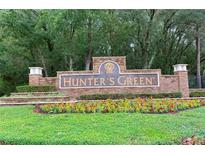 Community entrance sign for Hunter's Green amidst lush landscaping and mature trees at 9481 Highland Oak Dr # 710, Tampa, FL 33647