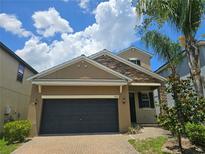 Inviting home featuring a stone-accented facade, well-maintained landscaping, and a two-car garage at 1022 Oliveto Verdi Ct, Brandon, FL 33511