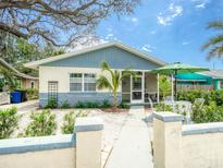 Charming single story home with a well-manicured front yard and welcoming entrance at 106 E Cedar St, Tarpon Springs, FL 34689