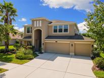 Beautiful two-story home with manicured lawn, three-car garage, and covered porch at 10837 Breaking Rocks Dr, Tampa, FL 33647