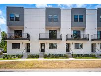 Modern townhomes with black-trimmed balconies, neutral paint, and landscaped entrances, providing curb appeal at 1316 W Carmen St # 2, Tampa, FL 33606