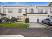 Inviting townhouse exterior with attached garage and manicured lawn at 13310 Thoroughbred Loop, Largo, FL 33773
