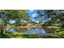 Scenic view of the pond and surrounding condos, framed by lush trees, offering a peaceful and serene environment at 3505 Tarpon Woods Blvd # P408, Palm Harbor, FL 34685