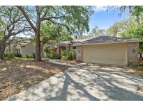 Charming one story home featuring a brick facade, attached garage, and mature landscaping at 6237 Greenwich Dr, Tampa, FL 33647