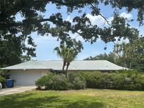 Charming single-story home with lush landscaping, mature trees, and an attached two-car garage at 1445 72Nd Ne Ave, St Petersburg, FL 33702
