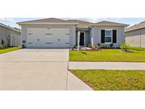 Charming single-story home with a well-manicured lawn, two car garage, and a welcoming entrance at 14498 Whitewater Way, Brooksville, FL 34604