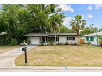 Charming single-story home with mature trees and a well-maintained lawn at 1526 San Mateo Dr, Dunedin, FL 34698