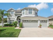 Charming two-story home with a three-car garage and well-manicured lawn and landscaping at 20102 Oakflower Ave, Tampa, FL 33647