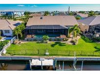 Beautiful aerial view of the home, pool, dock, and backyard on the canal at 2100 Aqui Esta Dr, Punta Gorda, FL 33950