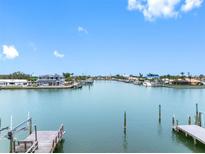 Expansive waterfront view showcases a serene waterway, docks, and beautiful homes under a bright blue sky at 440 115Th Ave, Treasure Island, FL 33706