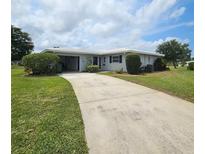 Charming single-story home with a well-manicured lawn and a concrete driveway leading to an attached garage at 7303 9Th W Ave # 7303, Bradenton, FL 34209
