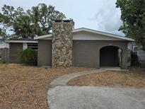 Charming one-story home featuring a stone chimney and covered entryway at 7307 50Th N Ave, St Petersburg, FL 33709