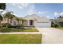 Charming single-story home with well-manicured lawn, mature landscaping, and a two-car garage at 7838 Trail Run Loop, New Port Richey, FL 34653