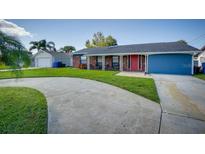 Charming single-story home featuring a well-maintained front yard and a colorful red front door at 8722 Thornwood Ln, Tampa, FL 33615