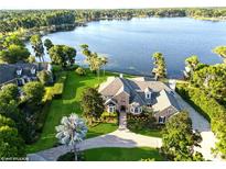 Breathtaking aerial view of a lakefront estate with lush landscaping, and a private waterfront at 919 Ballinger Rd, Lutz, FL 33548