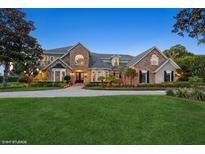 Elegant home with a brick facade, manicured lawn, and well-lit exterior, offering curb appeal and charm at 919 Ballinger Rd, Lutz, FL 33548