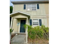 Two-story townhome featuring a covered entry and traditional windows with decorative shutters at 144 Douglas W Rd # F, Oldsmar, FL 34677