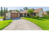 Charming single-story home with a well-maintained lawn and driveway leading to an attached garage at 2211 Bay Berry Ln, Clearwater, FL 33763