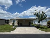 Charming single-story home with covered parking and well-maintained landscaping under a sunny, partly cloudy sky at 3041 Short Leaf St, Wesley Chapel, FL 33543