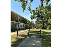 Charming condo with a lush green lawn and bench seating area for relaxing outdoors at 4051 58Th N St # 241C, Kenneth City, FL 33709