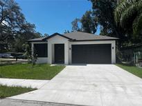 Charming single-story home with a well-manicured lawn and a spacious driveway leading to a two-car garage at 4241 E Palifox St, Tampa, FL 33610