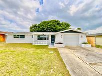Charming single-story home featuring a well-manicured lawn, bright white exterior, and attached single car garage at 5703 Andrea Dr, Holiday, FL 34690