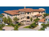Stunning waterfront home featuring a private gated entrance and lush tropical landscaping at 100 Sands Point Dr, Tierra Verde, FL 33715
