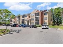 Three-story condo building with tan and rust colored facade and ample parking at 11901 4Th N St # 8207, St Petersburg, FL 33716