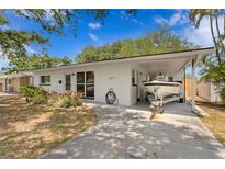 Charming single-story home with a carport and boat, complemented by beautiful landscaping and mature trees at 133 43Rd Ne Ave, St Petersburg, FL 33703