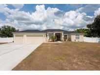 Charming single-story home with well-manicured lawn, three-car garage, and a welcoming entrance at 1521 Avondale Ridge Dr, Plant City, FL 33567