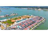 Beautiful aerial view of the community including tennis courts, baseball fields, pool and boat docks, with ocean views at 230 Medallion Blvd # G, Madeira Beach, FL 33708
