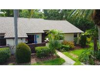 Inviting single-story home featuring a well-manicured lawn, vibrant landscaping, and a charming front entrance at 2913 Fig Ct, Palm Harbor, FL 34684