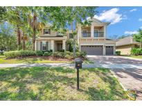 Inviting two-story home featuring a lush lawn, mature landscaping, and a spacious three-car garage at 5117 Longspur Ct, Lithia, FL 33547