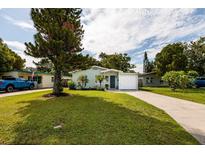 Charming single-story home featuring well-kept lawn, driveway, and attached garage at 5527 Kelly N Dr, St Petersburg, FL 33703
