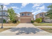 Charming two-story home featuring a wide driveway, a two car garage, and a landscaped front yard in a suburban neighborhood at 10424 Laguna Plains Dr, Riverview, FL 33578