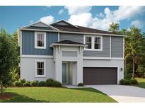 Charming two-story home with a gray color scheme, landscaped yard, and attached two-car garage at 12172 Cattleside Dr, Riverview, FL 33579