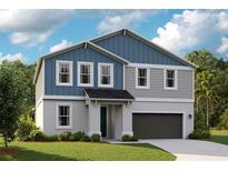 Charming two-story home featuring a welcoming entrance, attached garage, and beautifully landscaped front yard at 12174 Cattleside Dr, Riverview, FL 33579
