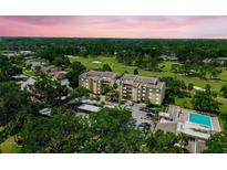 An aerial view of a condominium complex situated on a golf course near a swimming pool at 13618 Greenfield Dr # 105, Tampa, FL 33618