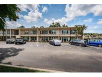 Beige condominium complex with ample parking and well-maintained landscaping on a sunny day at 5694 40Th N Ter # 423, Kenneth City, FL 33709